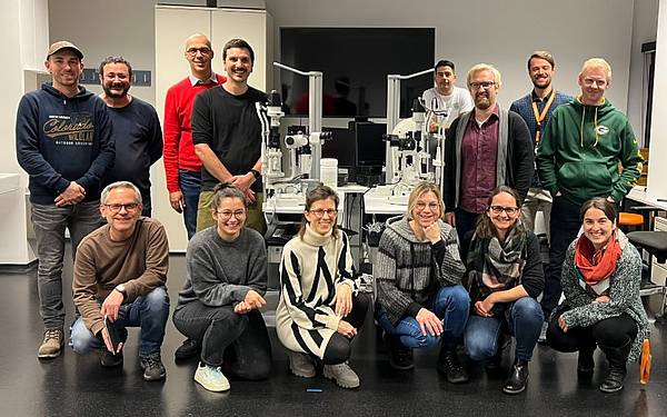 Eine Gruppe von Personen posiert für ein Foto. Vorne sind 6 Personen hockend, in der zweiten Reihe stehen die Menschen